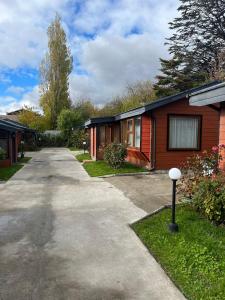a house with a driveway next to a house at Cabañas Español Coyhaique in Coihaique