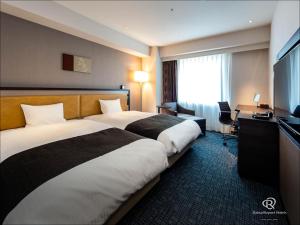 Cette chambre comprend deux lits et une télévision. dans l'établissement Daiwa Roynet Hotel Chiba Ekimae, à Chiba