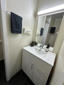 ein Bad mit einem Waschbecken und einem Spiegel in der Unterkunft Motel Bream in Mallacoota