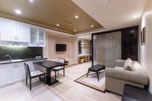 a kitchen and living room with a couch and a table at Admiral Premier Bangkok in Bangkok