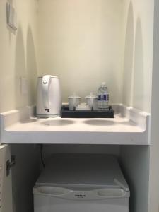 a kitchen sink with a coffee maker on a shelf at Eryi Hotel in Shanghai