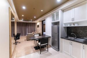 a kitchen and living room with a table and a couch at Admiral Premier Bangkok in Bangkok