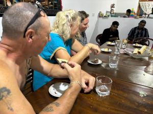 a group of people sitting at a table eating food at Travels Nest Homestay in Gampola
