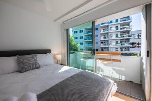 a bedroom with a bed and a balcony with a view at 3-Bedroom Unit with River Views and Balcony in Brisbane
