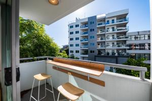 - un balcon avec deux tabourets et un bâtiment dans l'établissement 3-Bedroom Unit with River Views and Balcony, à Brisbane