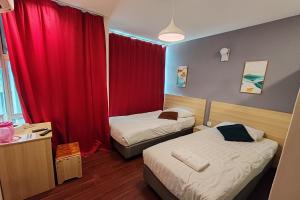 a hotel room with two beds and a red curtain at Hotel 18 in Ipoh