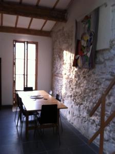 stół i krzesła w pokoju z kamienną ścianą w obiekcie Adoramaar- le loft w Marsylii