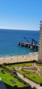 a view of a beach and the ocean with cranes at Depto Viña frente al mar in Viña del Mar