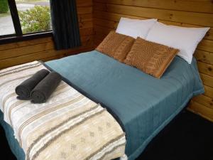 a bed with two pillows on it in a room at South Brighton Holiday Park in Christchurch