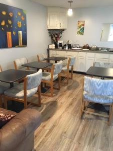 a dining room with tables and chairs and a kitchen at Big Sky Lodge in Rapid City