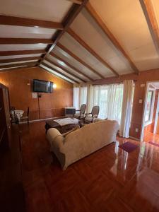 a living room with a couch and chairs in it at Cabañas Español Coyhaique in Coihaique