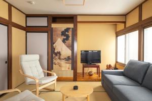 a living room with a couch and a tv at James House in Nozawa Onsen