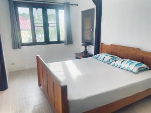 a bedroom with a bed with a pillow on it at Aforetime House @ Samui in Taling Ngam Beach