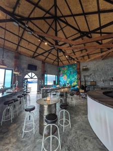 un restaurante con mesas y taburetes en una habitación en Goodtime Utopia Guesthouse en Ko Tao