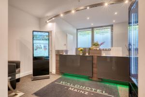 a lobby with two large screens in a building at Waldhotel in Mainz