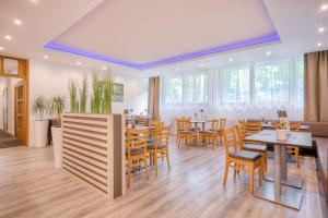 a dining room with wooden tables and chairs at Waldhotel in Mainz