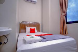 Ένα ή περισσότερα κρεβάτια σε δωμάτιο στο RedDoorz Syariah near Siloam Hospital 2