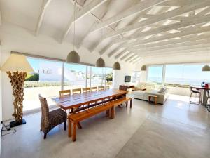 a dining room with a wooden table and chairs at Treasure in St Helena Bay