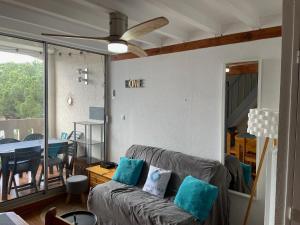 a living room with a couch and a ceiling fan at Plein Sud By Bellavista - 400 m de la plage - terrasse - parking in Argelès-sur-Mer