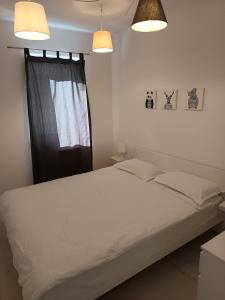 a bedroom with a white bed with two lights at BLUE APARTMENT 1 in Braşov
