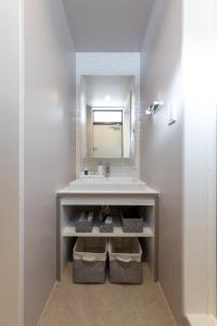 La salle de bains est pourvue d'un lavabo et d'un miroir. dans l'établissement villa vacances hamanako - Vacation STAY 43854v, à Hamamatsu