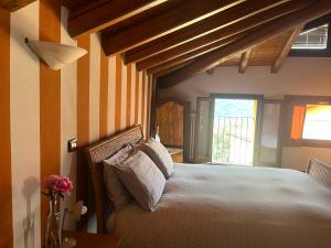 a bedroom with a bed with striped walls and a window at Casa Vacanza Castagna in Nesso