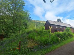 a barn on a hill with a field of flowers at Twin Deer Lodge in Glenfinnan