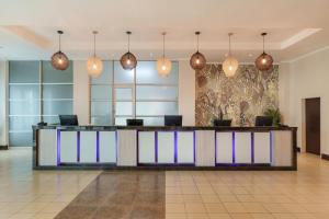 a lobby with a reception desk with colorful lights at Protea Hotel by Marriott Lusaka in Lusaka
