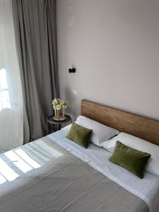 um quarto com uma cama grande e 2 almofadas verdes em Il Verdi home em Caserta