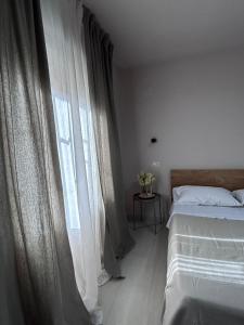 um quarto com uma cama e uma janela com cortinas em Il Verdi home em Caserta