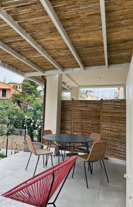 eine Terrasse mit einem Tisch, Stühlen und einem Zaun in der Unterkunft LaValeHouse in Marina di Campo