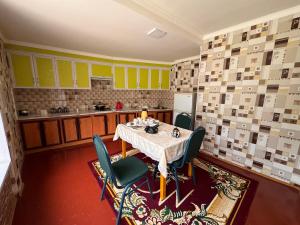 a kitchen with a table and chairs in a room at Panjrud guest house in Panjakent +10 photos