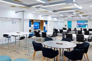 a conference room with tables and chairs and a whiteboard at London Marriott Hotel Kensington in London