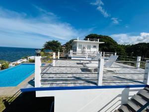 a house with a deck and a swimming pool at 1888 Beach Resort in Dumaguete