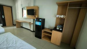 a room with a refrigerator and a tv in it at New Bandengan Beach Hotel in Jepara