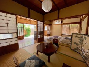 鎌倉市にある古民家の宿 鎌倉楽庵のベッド2台とテーブルが備わる客室です。
