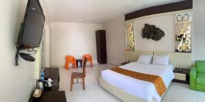 een hotelkamer met een bed en een televisie bij Hotel New Puri Garden in Kalibanteng-lor
