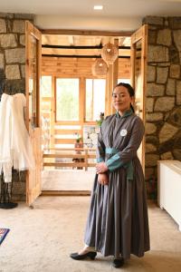 Eine Frau in einem Kleid, die vor einer Tür steht. in der Unterkunft Stone Hedge Hotel in Nubra