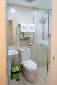 La salle de bains est pourvue de toilettes, d'un lavabo et d'une douche. dans l'établissement ALVEA HOTEL, à Puerto Princesa
