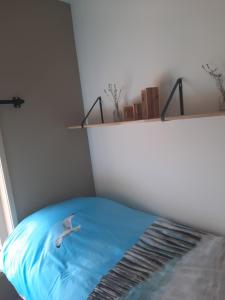 1 dormitorio con 1 cama con manta azul en zomerhuisje by the sea en Zoutelande