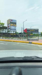 a view from a car of a gas station with billboards at Blest Loft 12 Manhattan Suites ITCC in Penampang