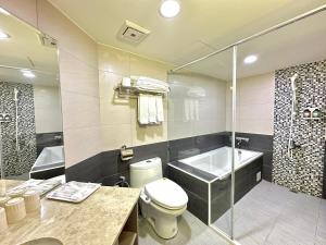 a bathroom with a toilet and a tub and a shower at Mei Hotel in Taichung