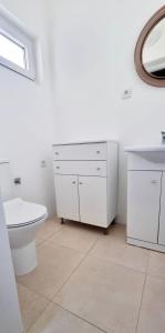 uma casa de banho com um WC, um lavatório e um espelho. em Pinhão House em Pinhão