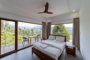 a bedroom with a bed and a balcony with a table and chairs at WINTEL WILD in Vālpārai