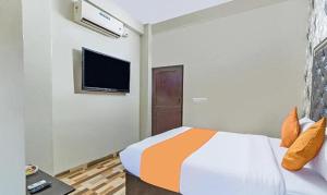 Schlafzimmer mit einem Bett und einem Flachbild-TV in der Unterkunft FabExpress Pavithraa Edition in Bangalore