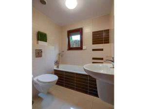 Un baño con inodoro, bañera y lavabo. en Claudia Comfortable holiday residence, en Łukęcin 19 fotos más
