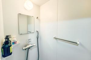 a bathroom with a shower and a mirror at 与那国島ホテル むんぶステイ 比川浜 in Sonai