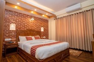 sypialnia z ceglaną ścianą i łóżkiem w obiekcie Madhuban Hotel w Katmandu