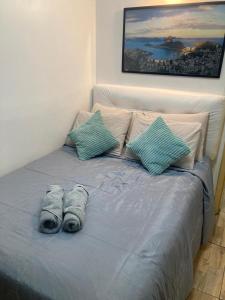 uma cama com duas almofadas em cima em Apartamento aconchegante no Hotel Quitandinha com vaga de garagem em Petrópolis