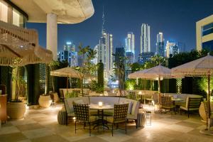 a patio with tables and chairs and a city skyline at The Lana - Dorchester Collection in Dubai